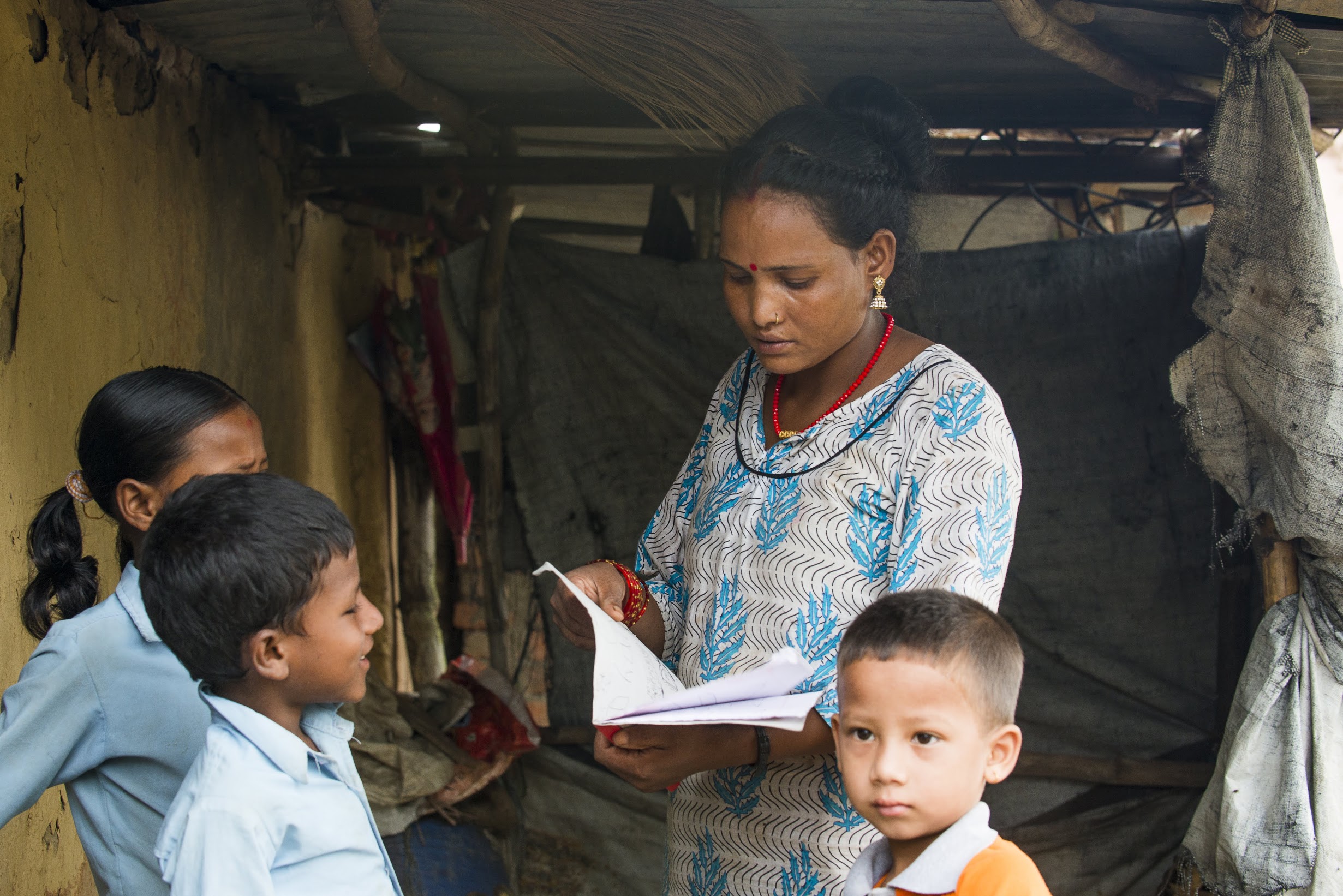 Dhana checks her children’s homework before sending them off to school