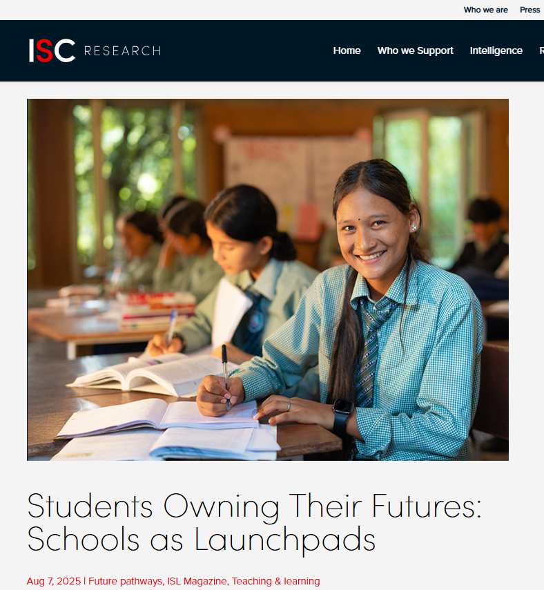 A smiling female student in a green checkered uniform sits at a desk with books and papers, surrounded by classmates in a classroom. The photo appears on a web page titled "Students Owning Their Futures: Schools as Launchpads.