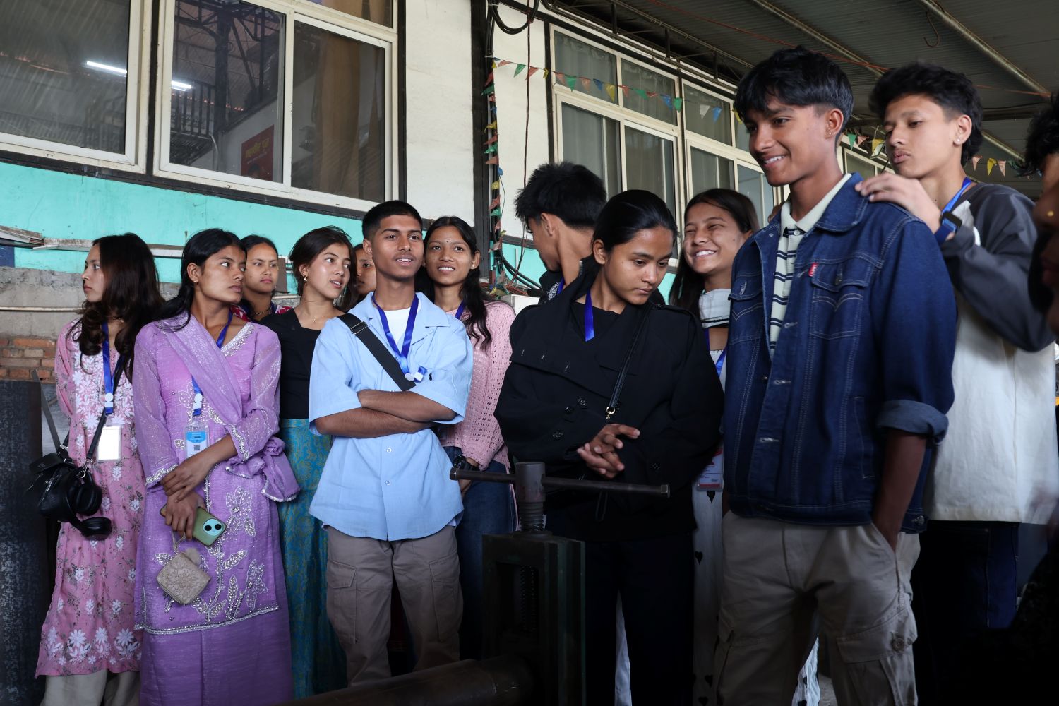 Students stand casually together outside a building.