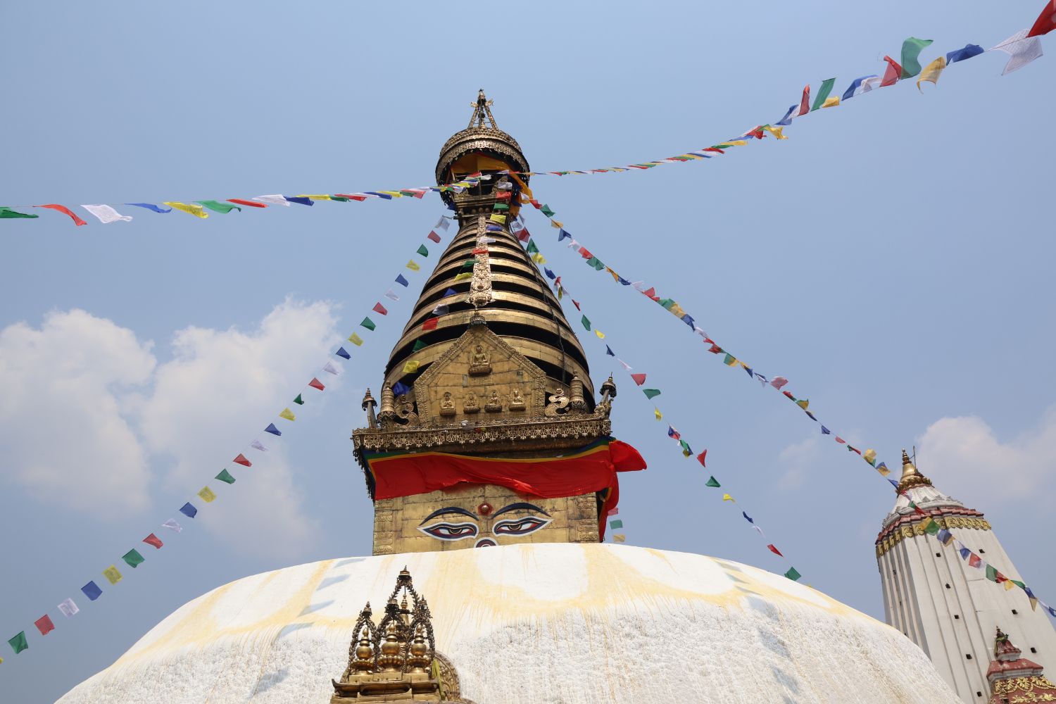 A gold temple in Nepal is decorated with prayer flags.